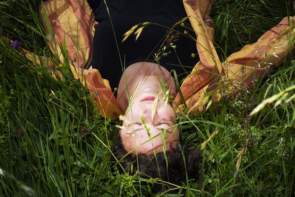 The photo shows the  electroacoustic composer and saxophone player laying in grass and enjoying life.